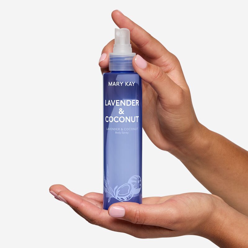 Light purple spray bottle with lavender and coconut illustrations in hand.&nbsp;&nbsp;