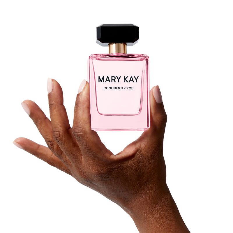 The light pink Mary Kay&reg; Confidently You&trade; bottle is held heroically by a hand