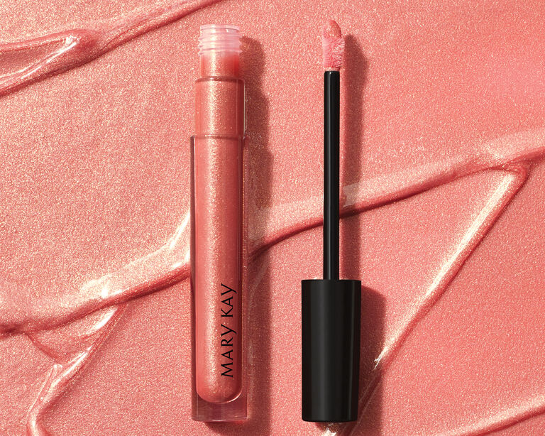 Tube of pink shimmer lip gloss with wand applicator in front of product swatch