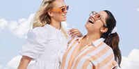 Female model in white outfit under blue sky
