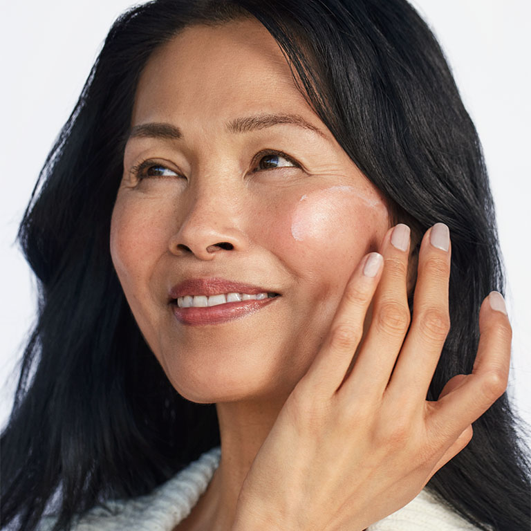 模特兒將玫琳凱防曬乳 SPF50+ 塗抹於臉頰上的畫面
