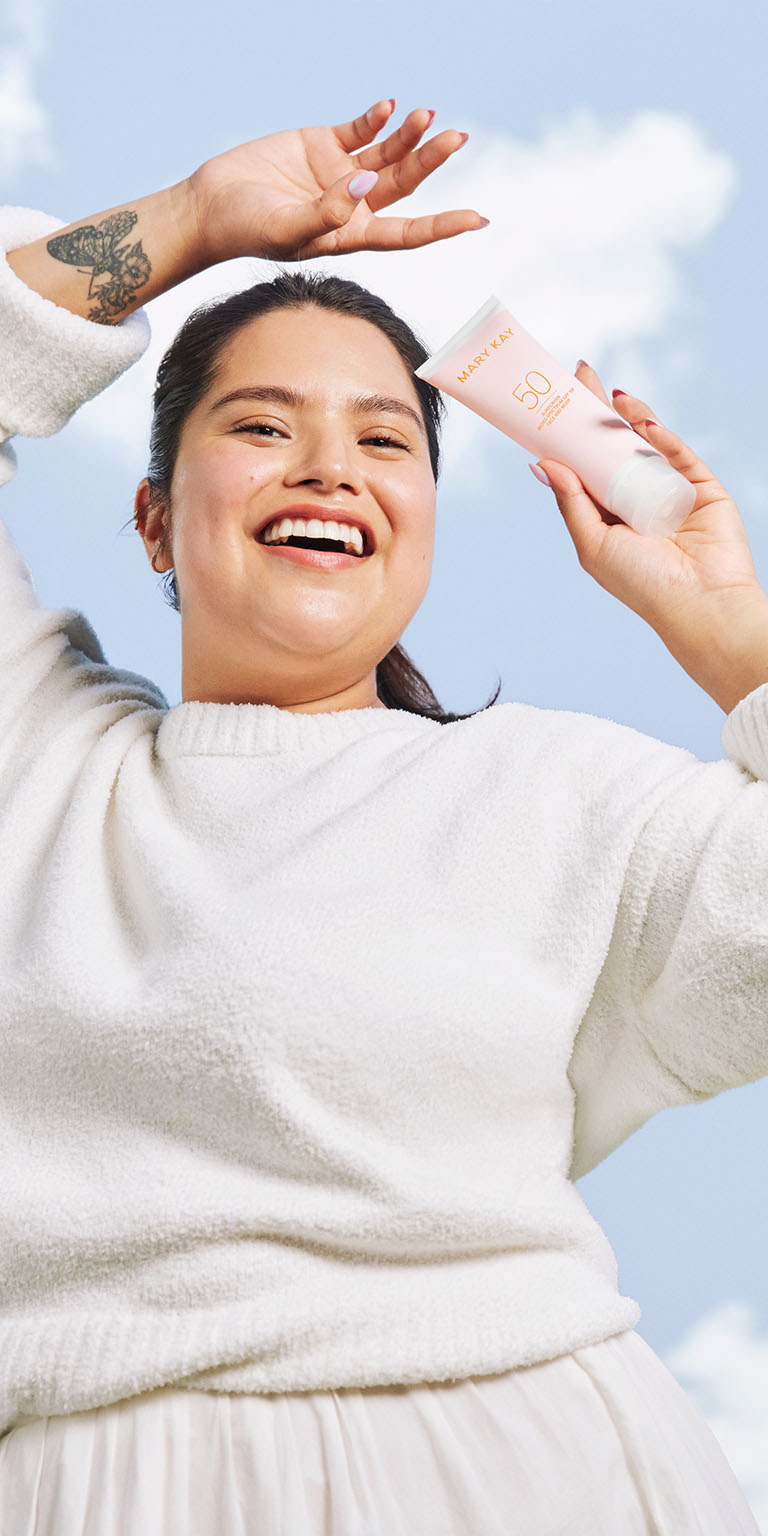 模特兒在藍天下手持防曬乳 SPF50+ 的畫面
